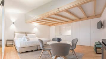 Un dormitorio moderno con cama, mesitas de noche, escritorio y silla.