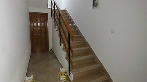 A staircase with a wooden handrail and a patterned rug at the bottom. - Sicilia Charme - Design and the Sea in Avola (Avola)