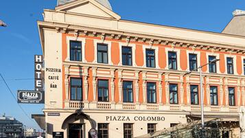 Ein historisches Gebäude mit einem Schild, auf dem 'Piazza Colombo' und 'Hotel' stehen, das ein Hotel und Restaurant anzeigt.