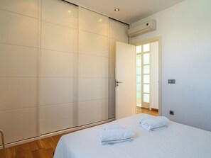 A bedroom with a bed, a wardrobe, and an air conditioning unit. - Villa Brisa by Interhome (Colònia Sant Pere)
