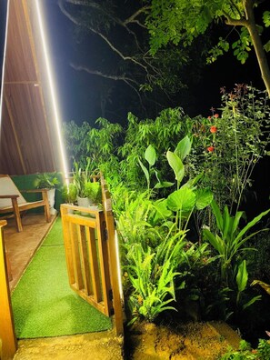 Un jardin avec différentes plantes et un banc en bois.