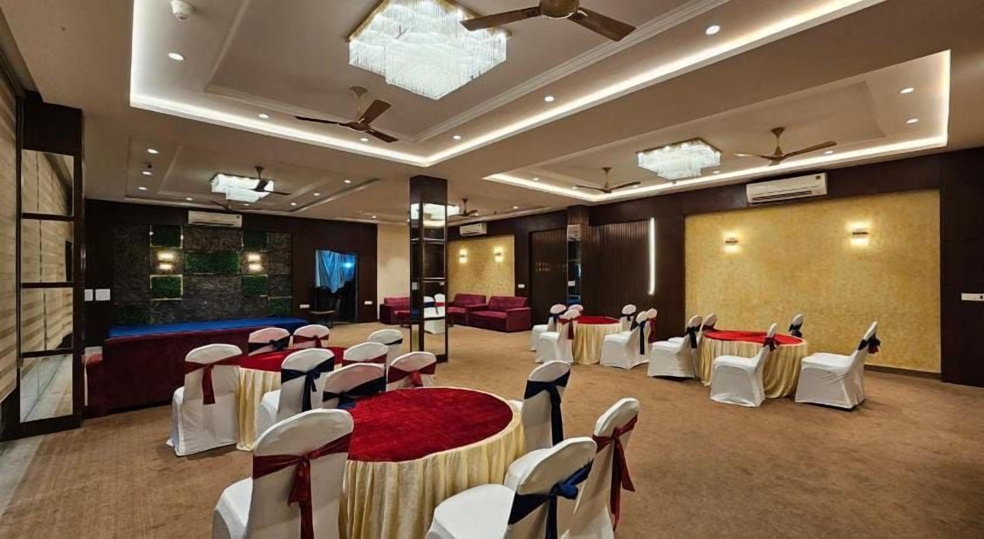 A conference room with round tables, white chairs, and red carpets.