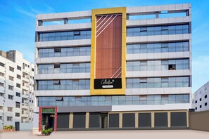 A multi-story building with a prominent vertical sign, large windows, and a gated entrance. - Super Collection O Manjari -Mundhwa Road (Pune)