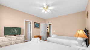 A hotel room with a bed, a desk, a television, and a ceiling fan. - The Victorian Golf Tee at Legends (Myrtle Beach)