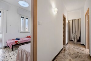 Un dormitorio con cama, ventana y puerta que da a un baño.