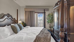 Habitación de hotel con una cama grande, un armario de madera, una ventana con cortinas y vistas al exterior.