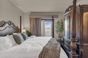 A hotel room with a large bed, a wooden wardrobe, a window with curtains, and a view of the outdoors. - Zermatt Mountain Retreat (Midway)