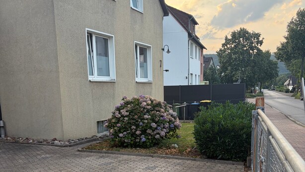A residential street with a paved driveway leading to a house with a small garden. - Holiday Home Milan with Private Terrace and Garden (Holzminden)