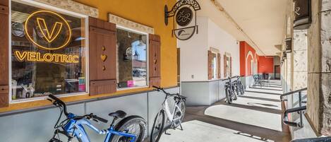 Una bicicleta estacionada frente a un edificio con un letrero de neón que dice 'VELOTRIC'.