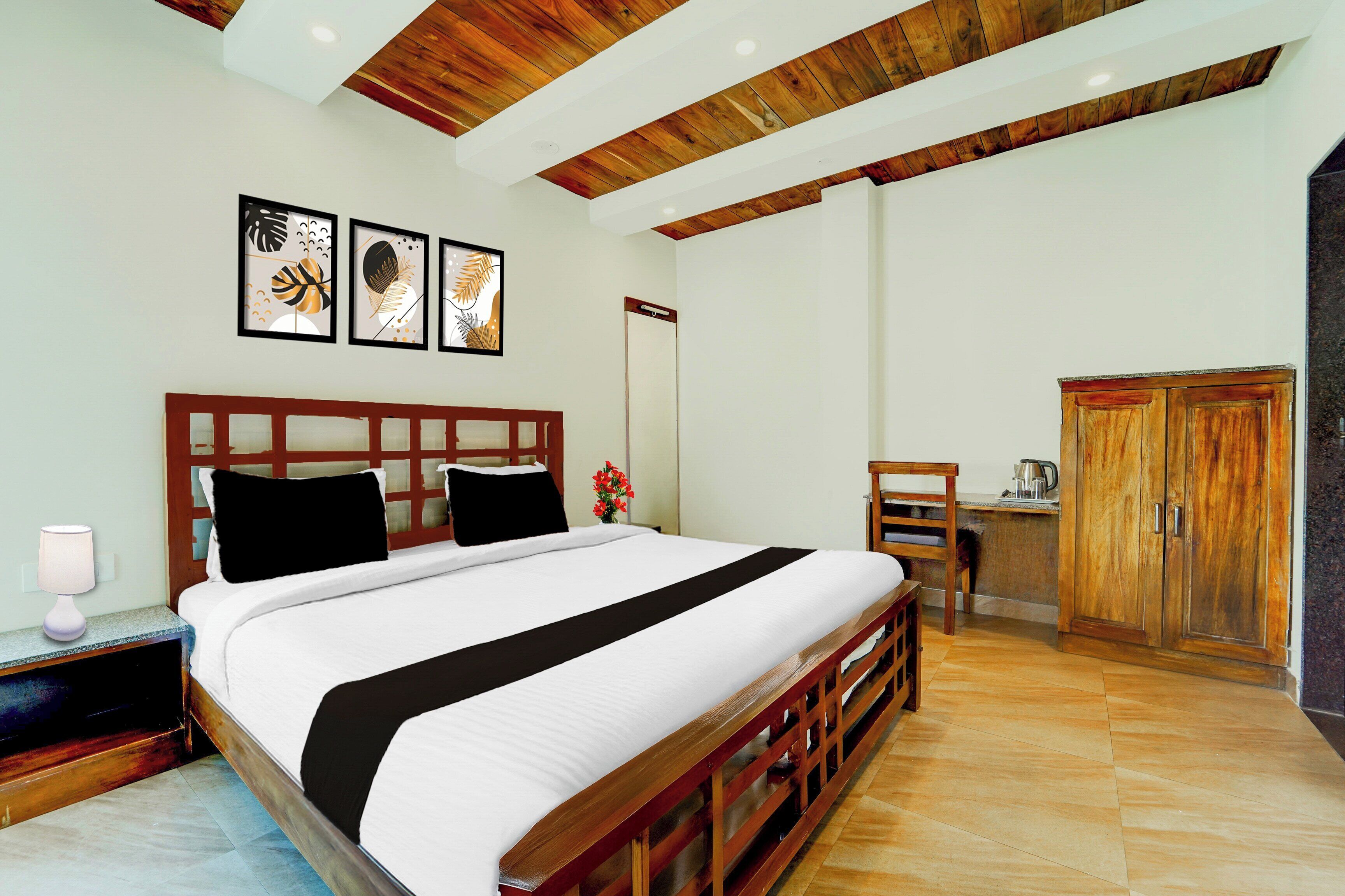 A bedroom with a wooden bed frame, a nightstand with a lamp, a desk with a chair, and a wardrobe.