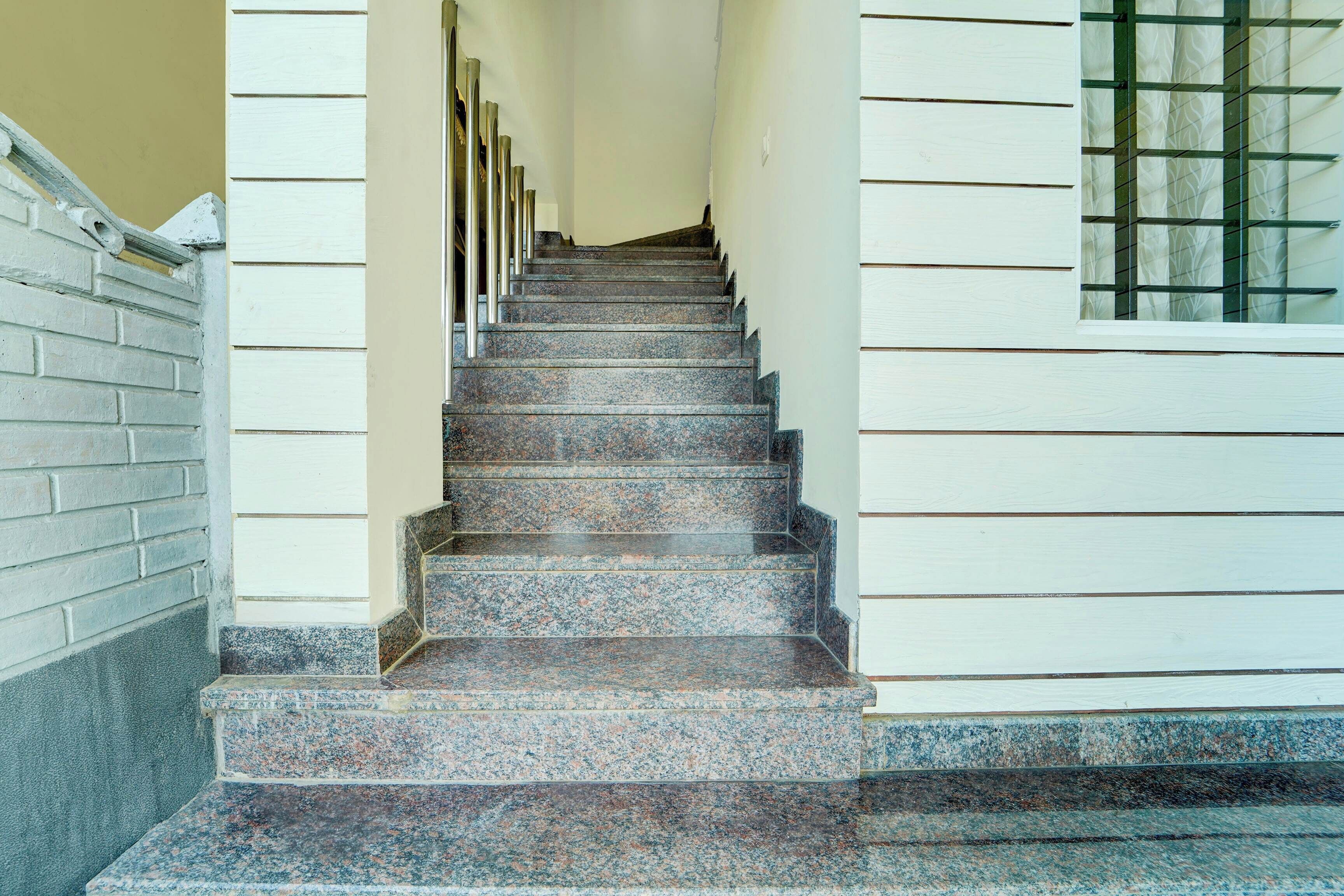 Eine Treppe mit Granitverkleidung, die zu einer Tür mit einer Glasscheibe führt.