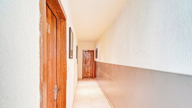 Ein Flur mit Holztüren und einer weißen Wand.
