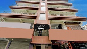 Un edificio de varios pisos con balcones y un cartel que indica que es una colección de apartamentos de empresa.