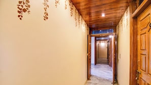 Un pasillo con una puerta de madera a la derecha y otra al final.