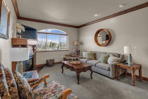 A living room with a fireplace, a sofa, a coffee table, and a television. - Zermatt Mountain Suite and 1bdr (Midway)