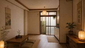 Um quarto japonês tradicional com tatames, uma mesa de madeira baixa, um lanterna de papel pendurada e uma porta deslizante que dá para uma varanda.