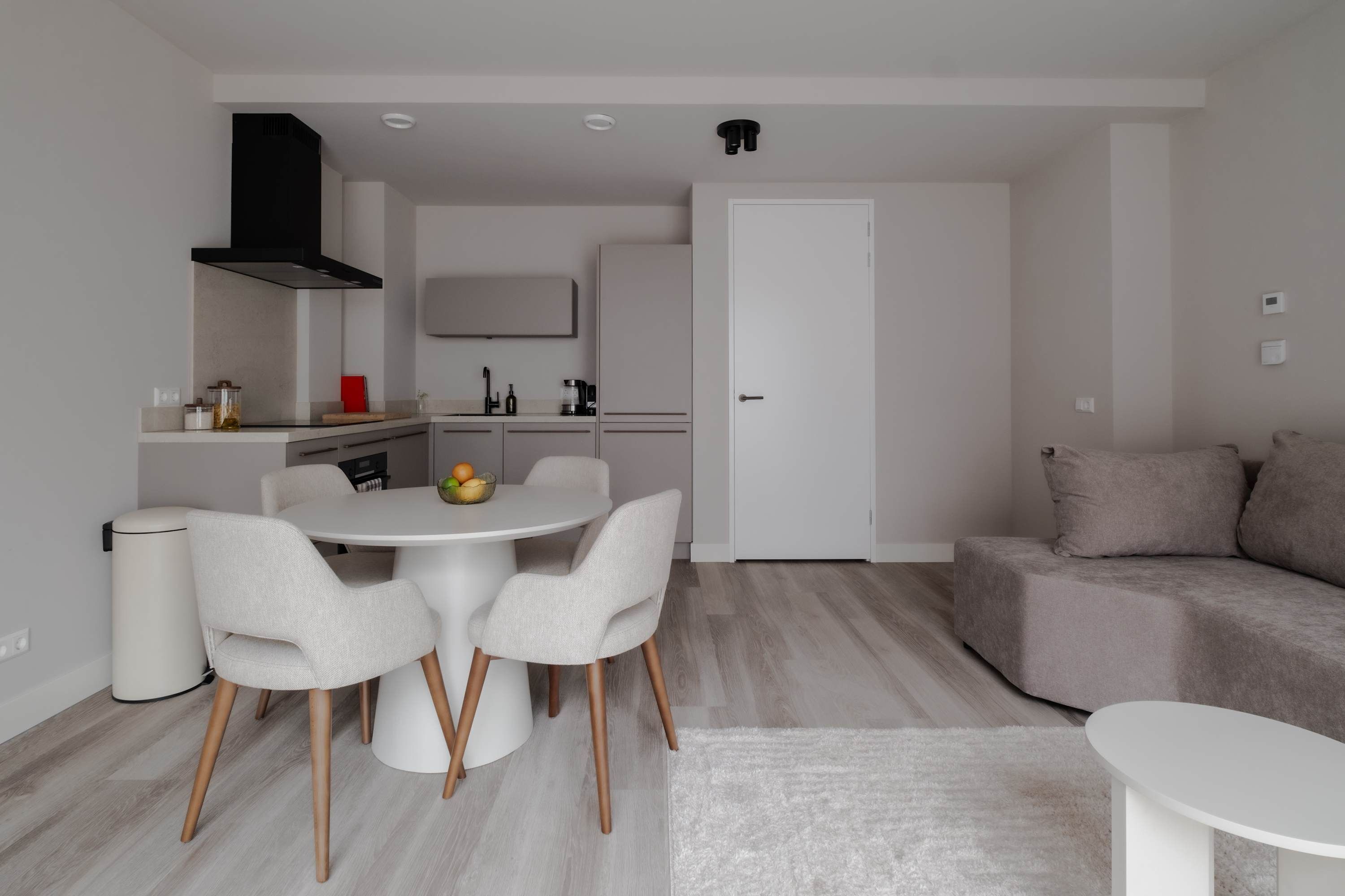 Un espacio habitable moderno con comedor, cocina y sofá.