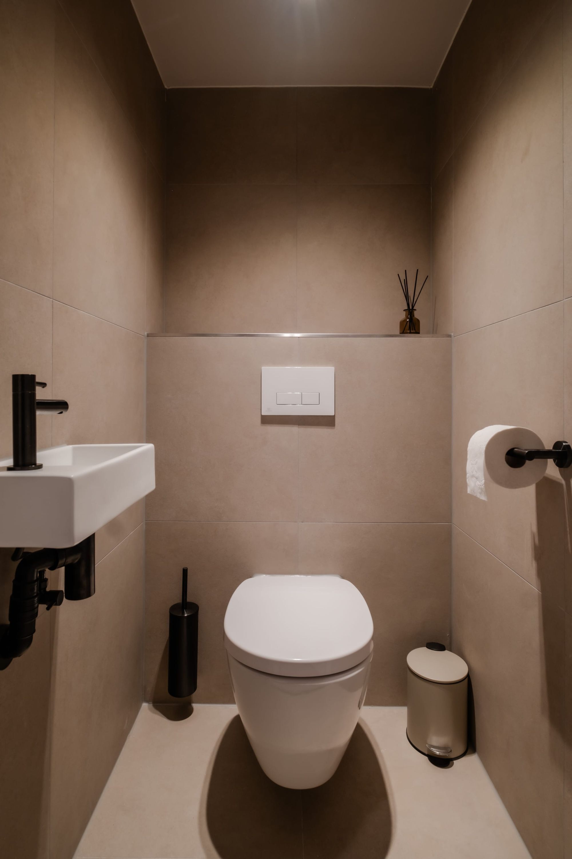 A modern bathroom with a white toilet, a sink, and a bidet.
