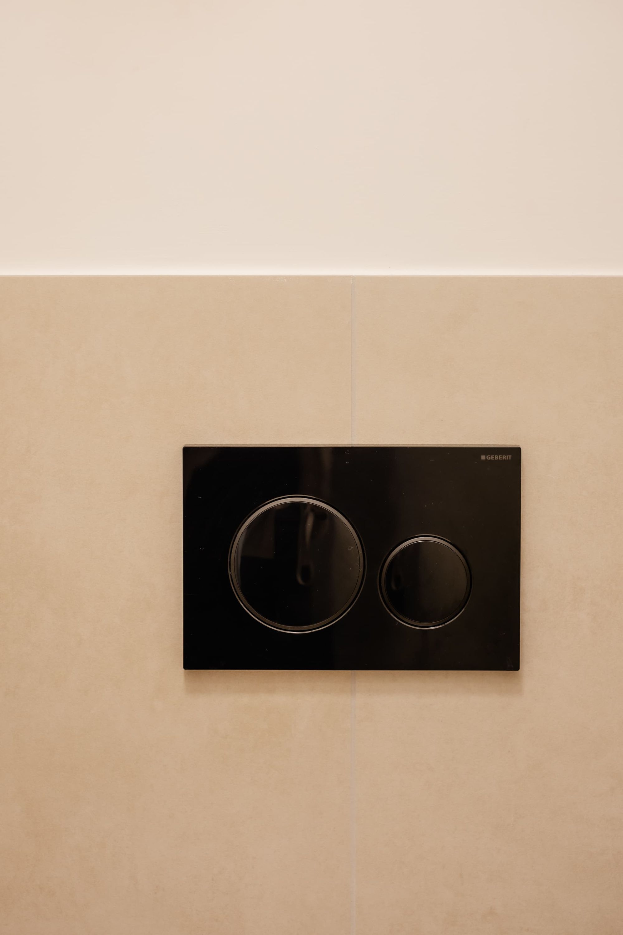 Un equipo de aire acondicionado GEBERIT negro montado sobre una pared color beige.