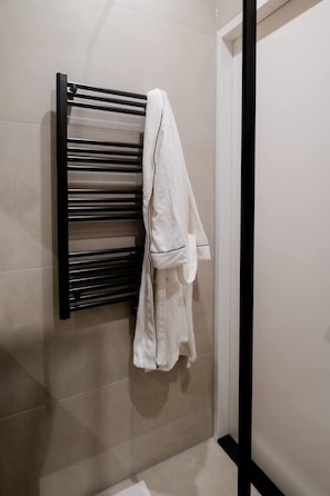 Un baño con un perchero que sostiene una toalla blanca.