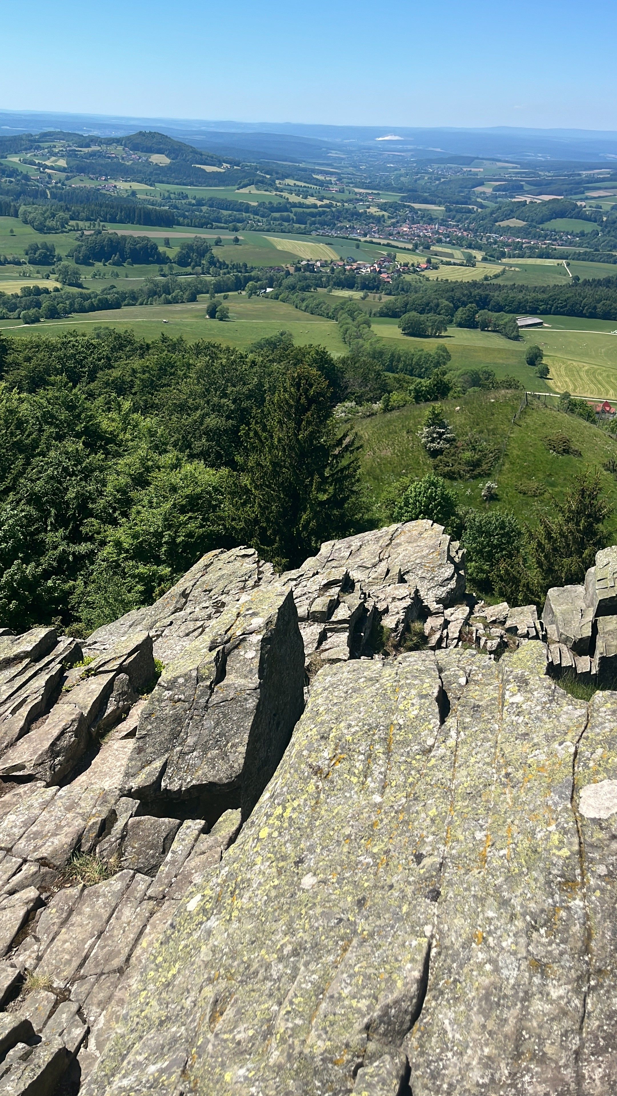 Eine felsige Landschaft mit Blick auf ein Tal und entfernte Gebäude.