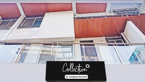 A multi-story building with a balcony, metal railings, and a sign indicating 'Collection Company-Serviced'. - Super Collection O Baner (Pune)