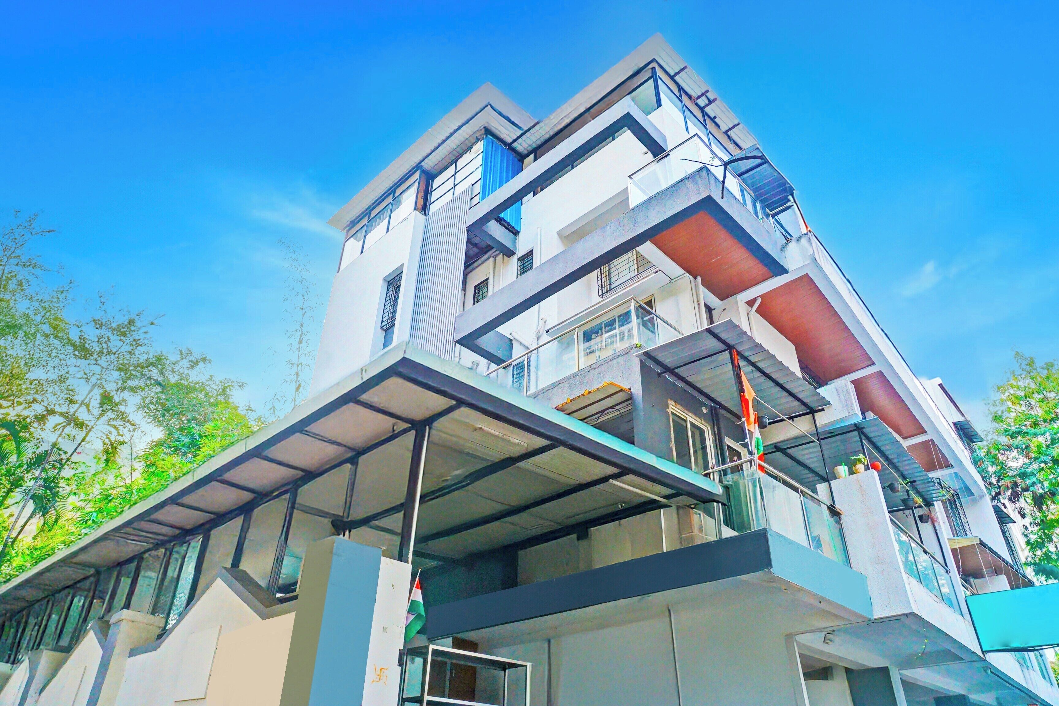 Um edifício de vários andares com design arquitetônico moderno, com varandas e grandes janelas.