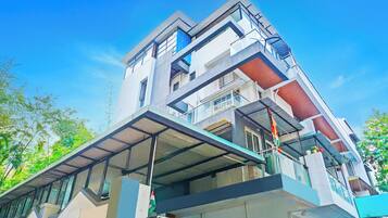 Um edifício de vários andares com design arquitetônico moderno, com varandas e grandes janelas.