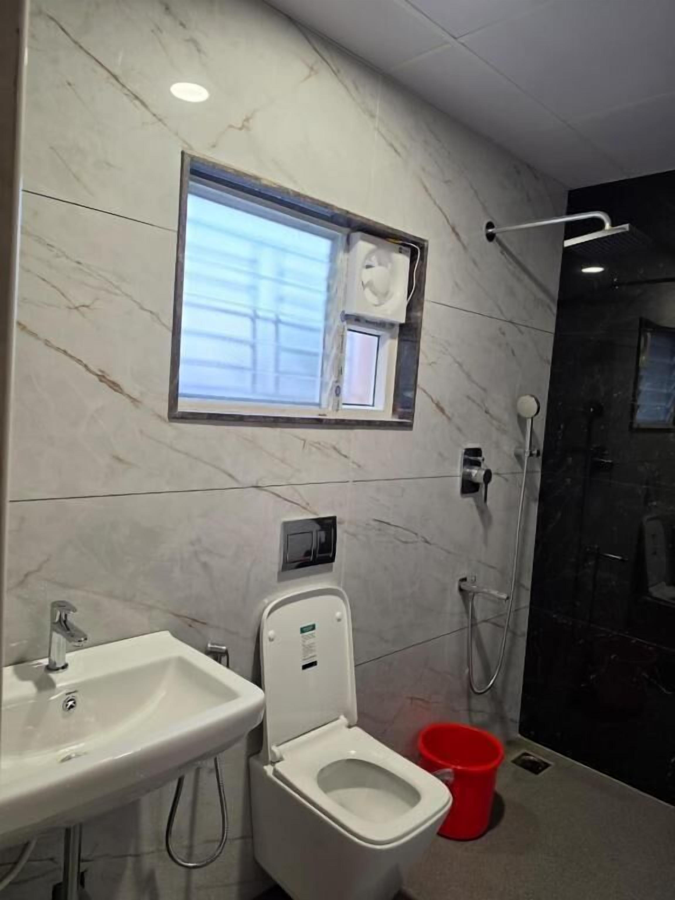 A bathroom with a toilet, sink, and shower.