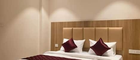 Un dormitorio moderno con una cama grande, cabecera de madera y un ventilador de techo.