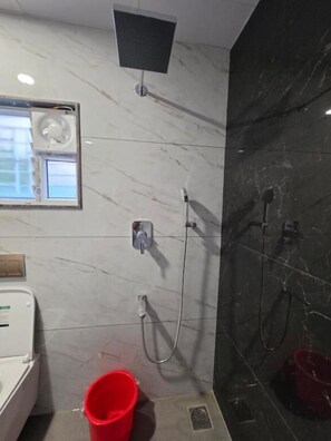 A bathroom with a shower, a toilet, and a sink.