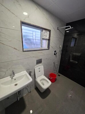 A bathroom with a sink, toilet, and a window.