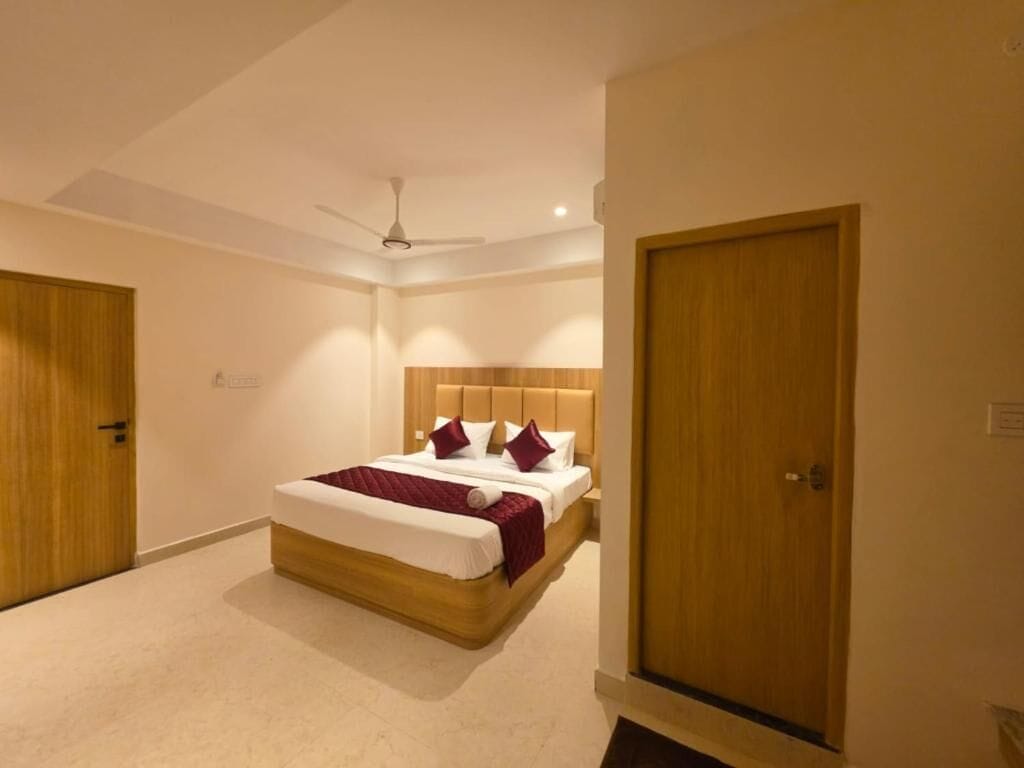 Un dormitorio con cama, ventilador de techo y puertas de madera.