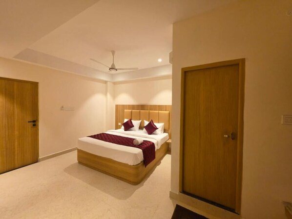 A bedroom with a bed, a ceiling fan, and wooden doors.