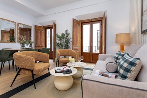 Una sala de estar moderna con un sofá, sillones, una mesa de centro y un comedor.