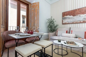 Un espacio habitable compacto con zona de comedor, un sofá y una mesa de centro.