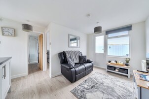 A modern living room with a leather sofa, a large window, and a minimalist design.