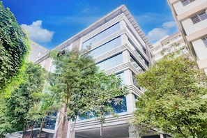 Un edificio moderno con varios pisos, ventanas amplias y techo plano.