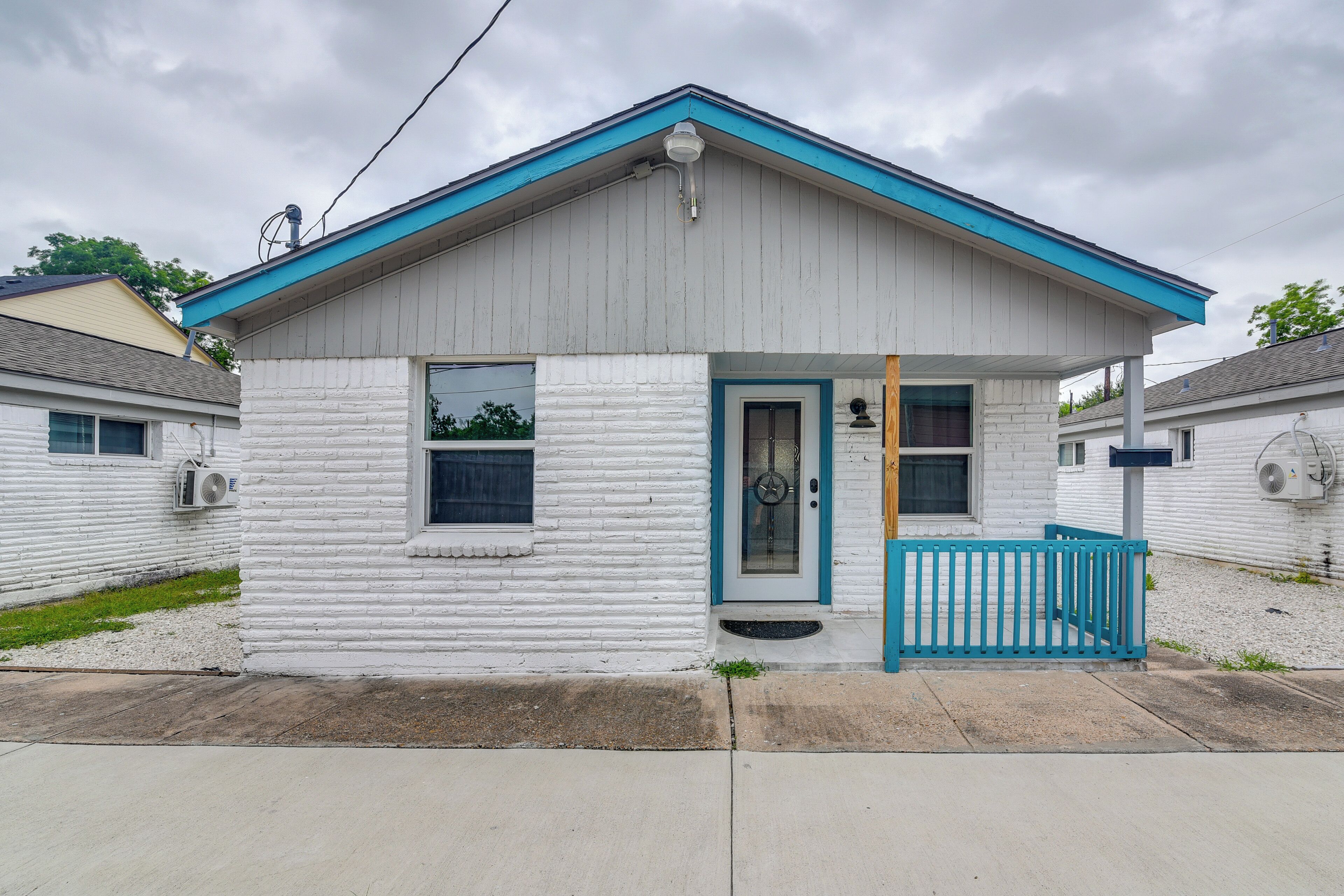 Une petite maison de plain-pied avec une porte bleue et un petit porche.