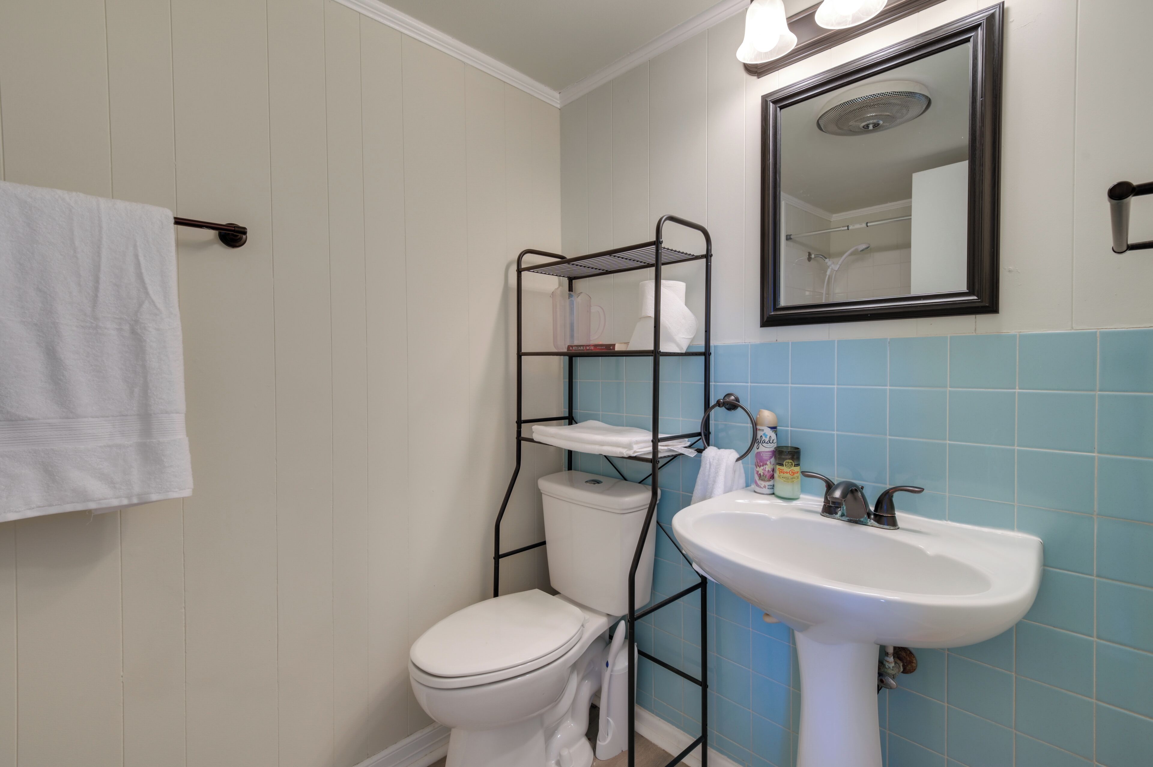 A bathroom with a white toilet, a white sink, and a towel rack.