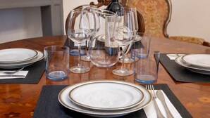 A dining table set with plates, glasses, and cutlery, with a bottle and menu in the background. - "Matilda Airport BG-4 -minute drive from BGY" (Bergamo)