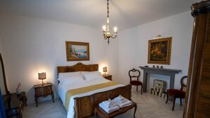 A hotel room with a large bed, a chandelier, a fireplace, and a painting on the wall. - "Matilda Airport BG-4 -minute drive from BGY" (Bergamo)