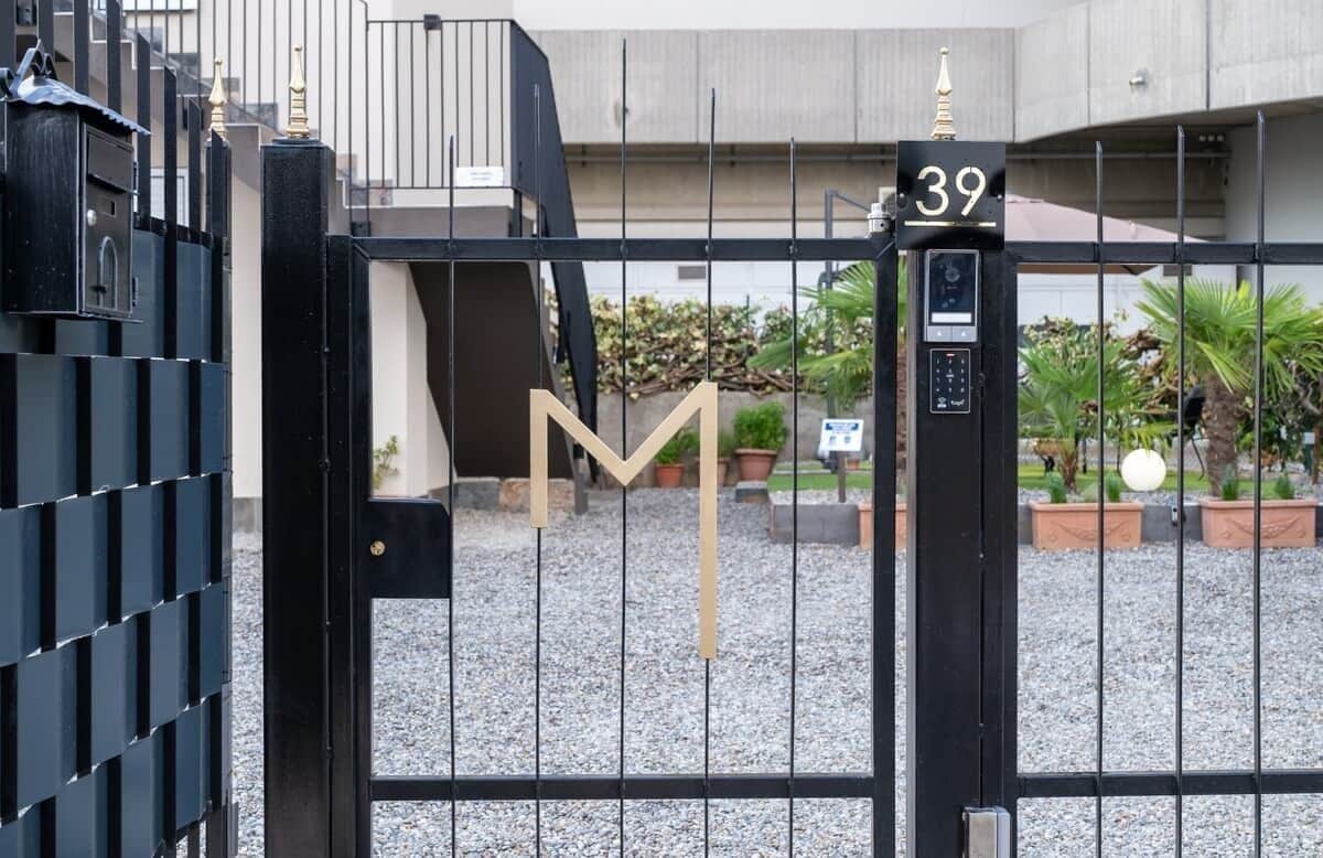 Une entrée fermée par un portail, avec un panneau indiquant le numéro « 39 » et un clavier pour ouvrir la porte.
