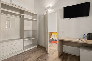 A room with a white wardrobe, a desk with a kettle, a water bottle, and a remote control. - Double Room in 'La Cà De' Mi Vecc' with Open Terrace (Costa)
