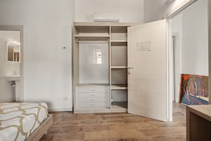 Un dormitorio con cama, armario y un cuadro en la pared.