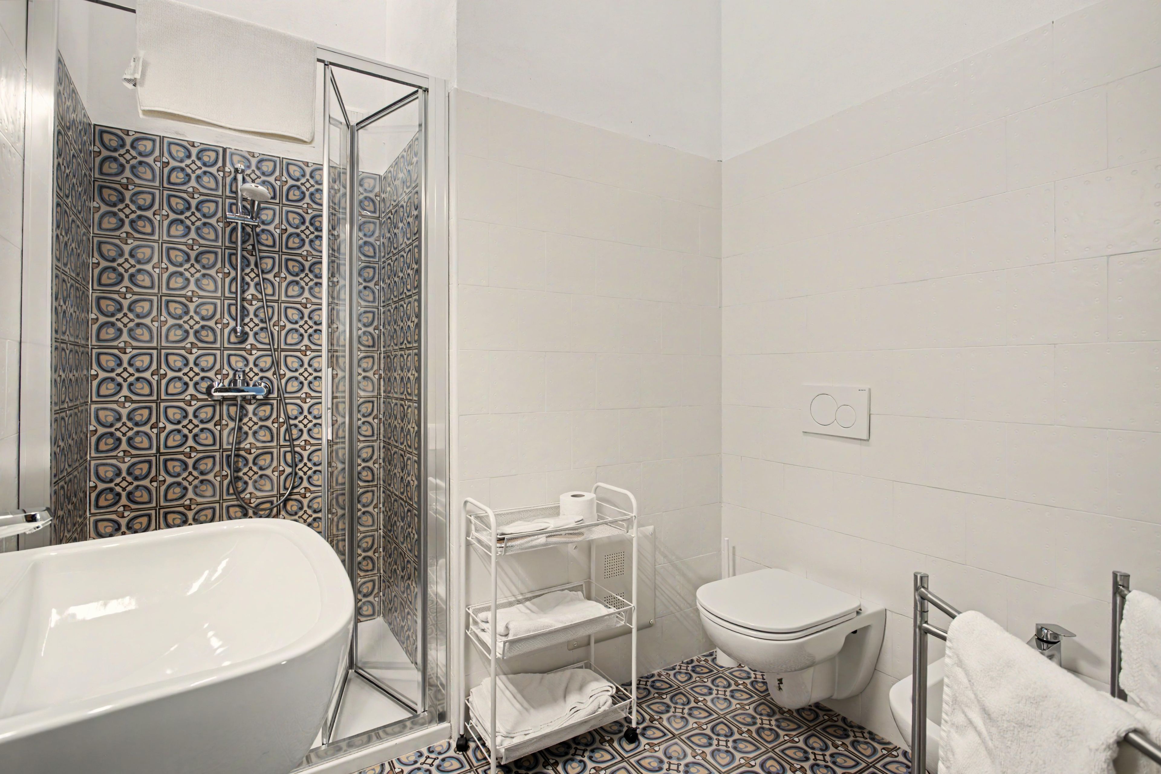 Een badkamer met een bad, toilet en douche.