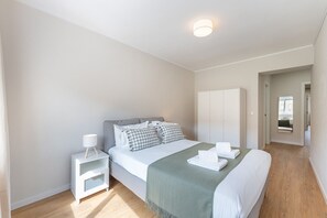 Ein Schlafzimmer mit Bett, Nachttisch, Kleiderschrank und Spiegel.