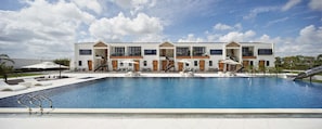Una piscina al aire libre, sombrillas, tumbonas