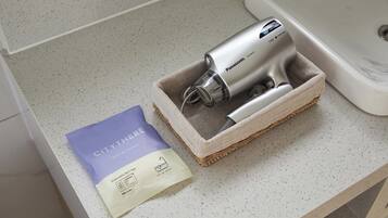 A Panasonic hair dryer in a woven basket on a countertop, next to a purple and white package labeled 'CITYTHERE'.