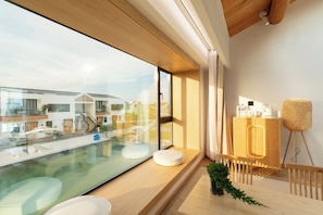 A modern interior with a large glass window, wooden flooring, a small indoor pool, and a wooden cabinet with toiletries. - Shanghai Fangwai Resort & Homestay (Shanghai)